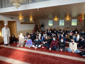 Das Bild zeigt die Kinder der HBS beim Moscheebesuch in einer Gruppe zusammensitzend