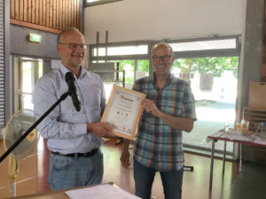 Der Schulleiter der Heinrich-Böll-Schule, Alexander Hauptmann, (l.) ernannte Fritz Ueberall (r.) zum „Ehrenhausmeister“. Anlass war seine Verabschiedung in den wohlverdienten Ruhestand.