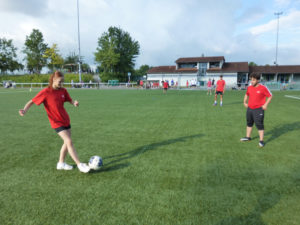 Das Bild zeigt im Vordergrund zwei Schüler mit Ball beim Spiel.