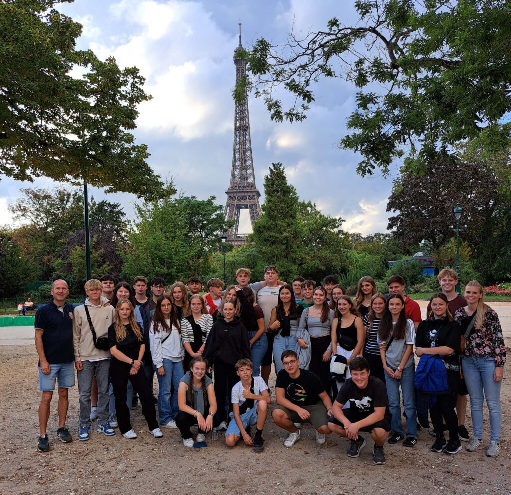 Die Teilnehmer der Paris-Ausfluges stehen vor dem Eifelturm