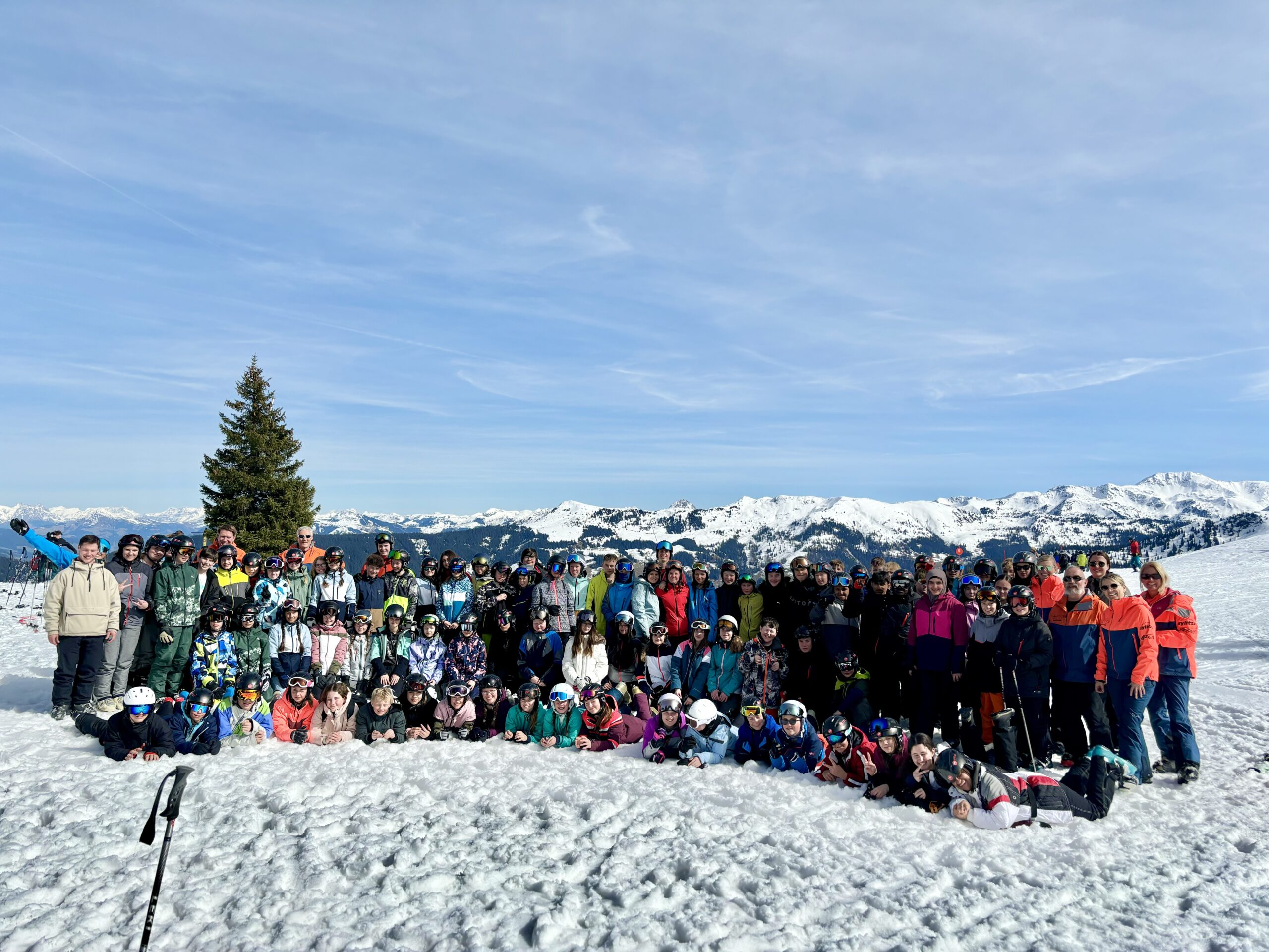 Die Teilnehmer/innen der Skifreizeit in einer Reihe auf einem verschneiten Gipfel