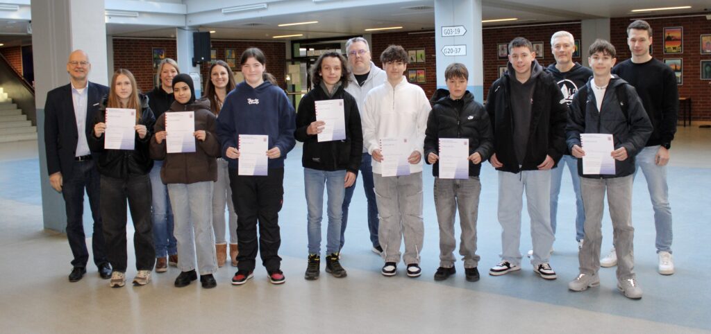 Die Sieger vom Mathewettbewerb stehen im Foyer mit Urkunden in einer Reihe