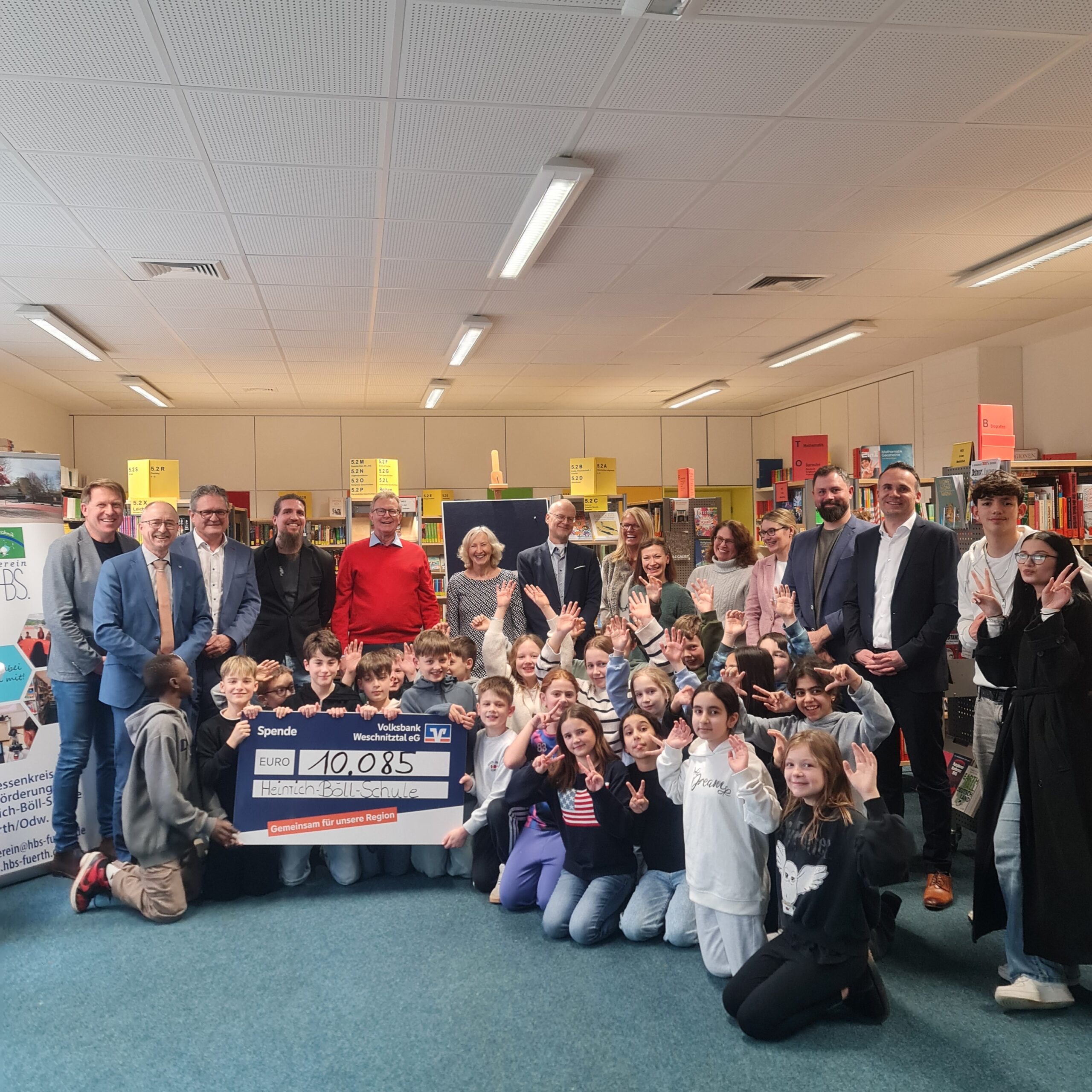 Spendenübergabe im Beisein der Voba, der Schulleitung, Lehrkräften und mehreren Schüler/innen in der Mediothek