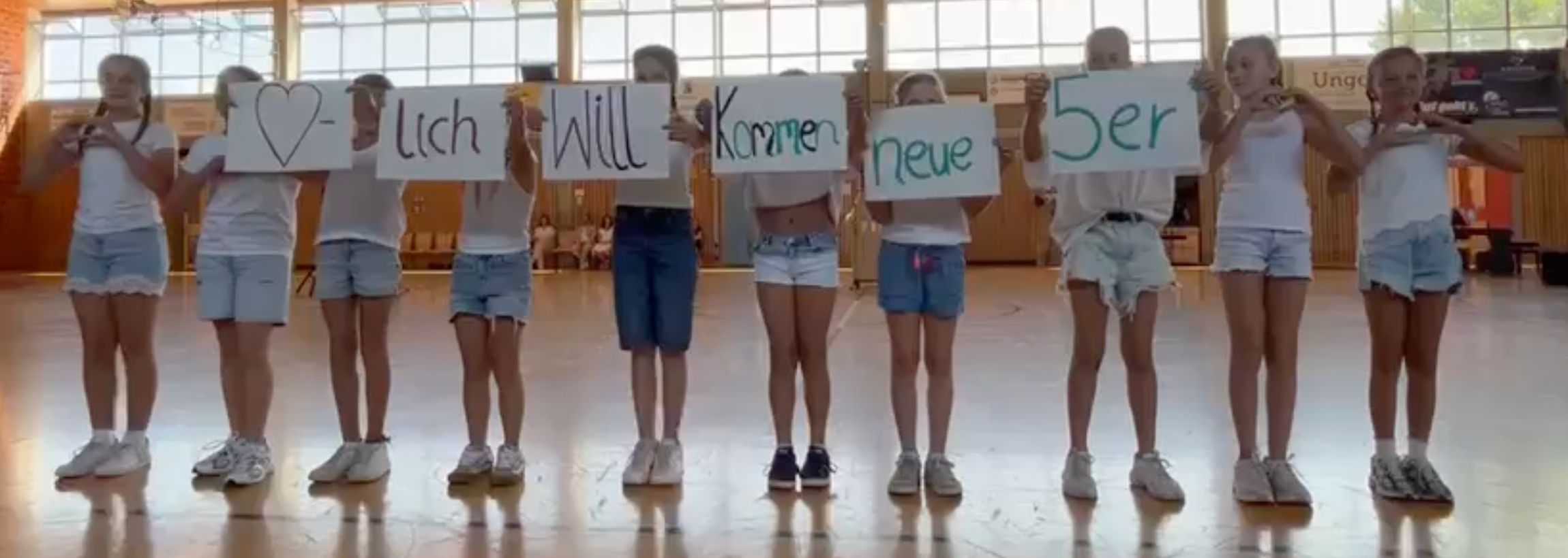 Schüler/innen stehen in einer Reihe und Halten Wortkarten mit der Aufschrift